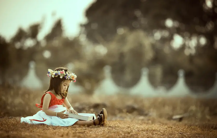 little girl reading outside