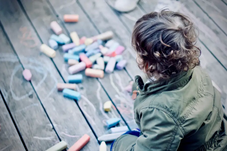 child playing with color chalk