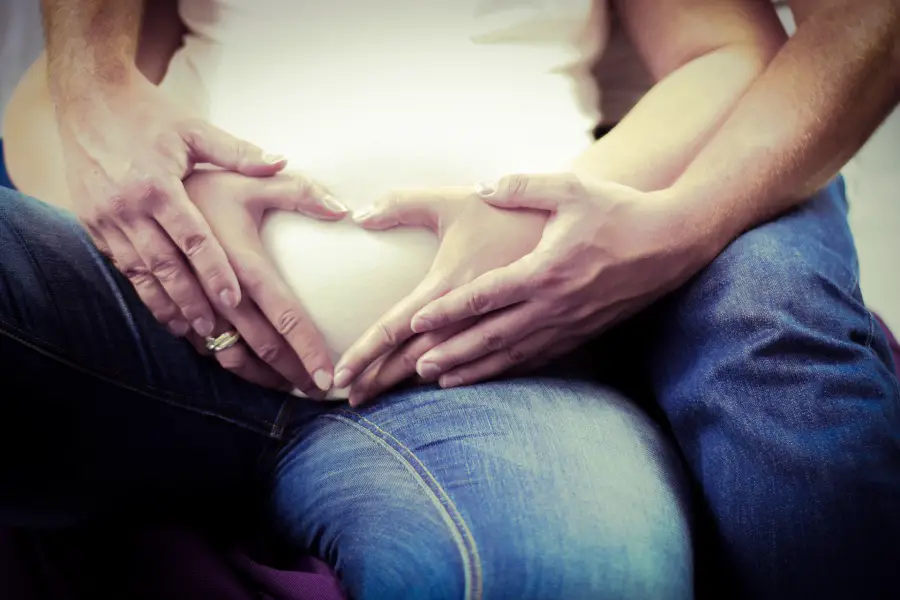 man hugs pregnant woman