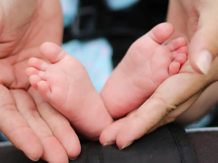 mother holding baby's feet